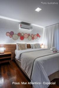 a bedroom with a large white bed with avertisement at Pousada Mar Atlântico in Fernando de Noronha