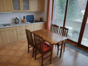 a kitchen with a wooden table and chairs and a window at Apartment with 2 rooms and kitchen Pension Kubu in Špindlerův Mlýn