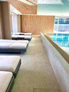 a row of beds in a room with windows at Bad Seerose mit Seeblick, Dachterrasse, Pool und Sauna in Bad Saarow