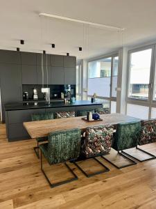 a kitchen with a large wooden table and chairs at Bad Seerose mit Seeblick, Dachterrasse, Pool und Sauna in Bad Saarow