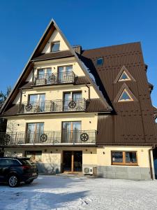 a building with a car parked in front of it at Rozetka Białka in Białka Tatrzanska