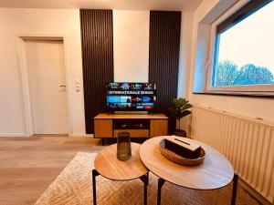a living room with a table and a television at Bremen 3 Zimmer Wohnung Achim Uphusen Direkt an der Autobahn Bremer Kreuz! in Bremen