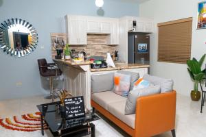 a living room with a couch and a kitchen at Addvantage Point Apartments in Montego Bay