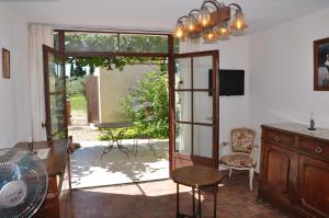 an open door to a patio with a table and chairs at Gîte Du Mas Des Oliviers in Mézoargues