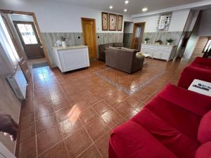 a living room with a red couch and a kitchen at Hotel La Braña in San Isidro +18 photos
