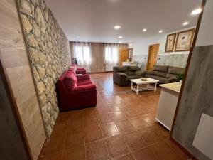 a living room with couches and a stone wall at Hotel La Braña in San Isidro