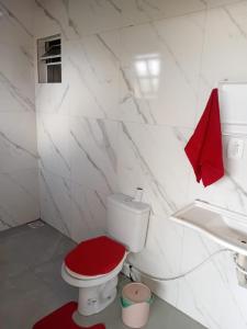 a bathroom with a toilet with a red lid at Casa da família Castro in Capão da Canoa