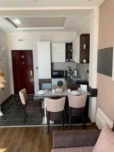 a kitchen with a table and chairs in a room at Milmari I2 Lux Apartman in Kopaonik