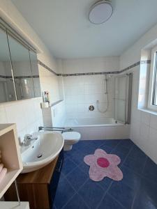 a bathroom with a sink and a toilet and a tub at Ferienwohnung Pipflhof in Wattens +5 photos