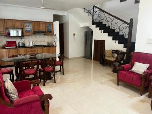 a kitchen and living room with a table and chairs at Serene villa In North Goa in Arpora