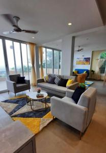 a living room with two couches and a table at Boom Party Villa in Pirangut