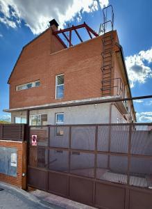 a building with a fence and a garage at Apartamentos Noviembre in Madrid