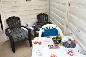 two chairs and a table on a patio at Studio enchanteur au Diamant avec terrasse privée - 20 m² in Le Diamant