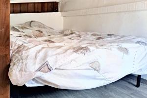 an unmade bed with a blanket on it in a room at Studio enchanteur au Diamant avec terrasse privée - 20 m² in Le Diamant