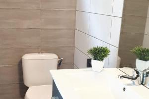 a bathroom with a toilet and a sink with two plants at Studio enchanteur au Diamant avec terrasse privée - 20 m² in Le Diamant +4 photos