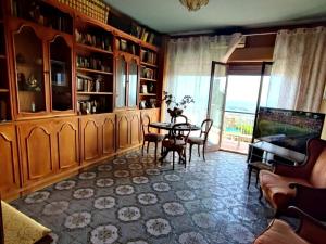 Una sala de estar con una mesa y un balcón. en IL BALCONE SULLA VALLE DEI TEMPLI, en Agrigento
