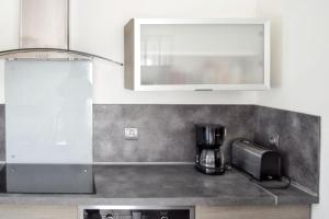 a kitchen with a counter top with a coffee maker at Maison charmante à Saint-Georges-de-Didonne avec jardin in Saint-Georges-de-Didonne +13 photos