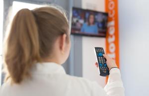 a little girl holding a remote control in front of a tv at easyHotel Victoria in London