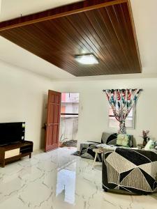 a living room with a wooden ceiling at Loven Transient House in Dauis