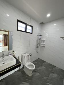 a bathroom with a toilet and a sink and a window at Plakang pool villa ปลากั้งพูลวิลล่า in Chiang Rai