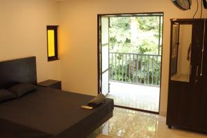 a bedroom with a bed and a sliding glass door at Greens Homestay Varkala in Varkala