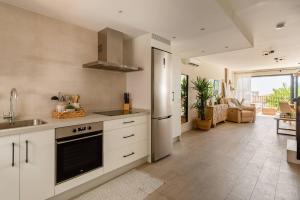 kuchnia z białymi szafkami, zlewem i lodówką w obiekcie Duplex With Sunny Terrace Located In Mijas Pueblo w mieście Mijas