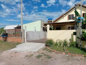 a house with a gate in front of it at Casa da família Castro in Capão da Canoa