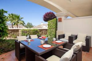 Un patio con una mesa y sillas en un patio. en Mediterranean Townhouse Calagolf, en Mijas