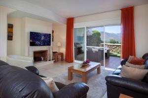 Una sala de estar con un sofá y una chimenea. en Mediterranean Townhouse Calagolf, en Mijas