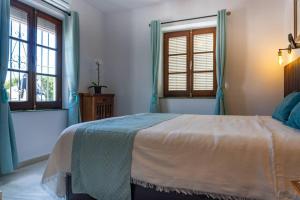 a bedroom with a bed and two windows at Idyllic Townhouse with Scenic Views Mijas Pueblo in Mijas +22 photos