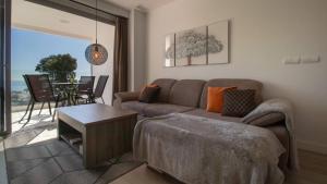 a living room with a couch and a table at Stylish Central Apartment & Panoramic Views Mijas in Mijas