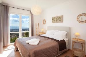 een slaapkamer met een bed en een groot raam bij Cozy townhouse Mijas with views in Mijas