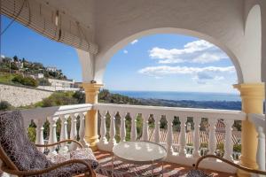 een balkon met stoelen en uitzicht op de oceaan bij Cozy townhouse Mijas with views in Mijas