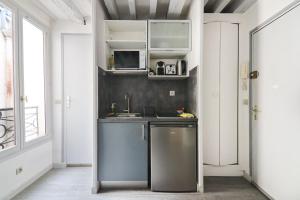 une cuisine avec un évier et un micro-ondes dans l'établissement Élégant Studio Appartement Quartier Ile Saint Louis Free Netflix, à Paris