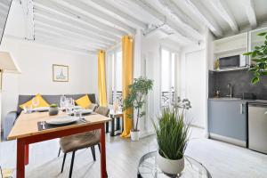 un salon avec une table et une cuisine dans l'établissement Élégant Studio Appartement Quartier Ile Saint Louis Free Netflix, à Paris
