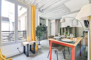 une salle à manger avec une table et une grande fenêtre dans l'établissement Élégant Studio Appartement Quartier Ile Saint Louis Free Netflix, à Paris
