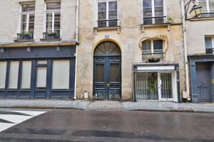 un bâtiment avec des portes bleues dans une rue de la ville dans l'établissement Élégant Studio Appartement Quartier Ile Saint Louis Free Netflix, à Paris