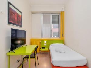 Cette chambre comprend un lit, une table et un bureau. dans l'établissement B&B HOTEL Milano Ornato, à Milan