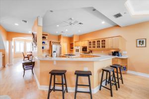 a kitchen with a large island with bar stools at Coconut Palm House in Captiva +33 photos