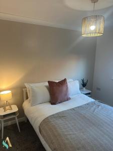 a bedroom with a bed with pillows and a lamp at Overton View in Stockton-on-Tees