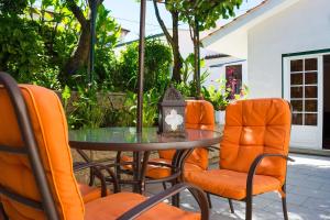 a glass table and orange chairs and a table and chairs at Casa de Alvite in Alvito