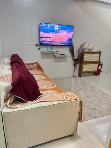 een woonkamer met een bed en een flatscreen-tv bij Lecels Haven Place in Dauis +12 foto's