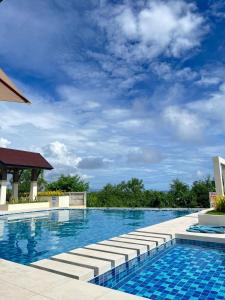 een zwembad in een resort met een blauwe lucht bij Lecels Haven Place in Dauis