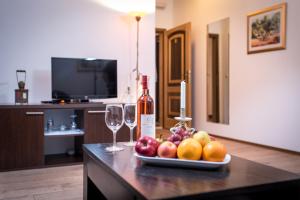 Apartments Zavala في Ravno: طاولة مع طبق من الفاكهة وكؤوس النبيذ