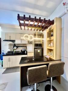 een keuken met een eiland met twee barkrukken bij Lecels Haven Place in Dauis