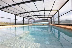 an indoor swimming pool with a large glass ceiling at La Creu De La Pinya in Berga