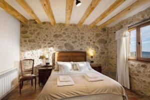 a bedroom with a large bed in a stone wall at La Creu De La Pinya in Berga +34 photos