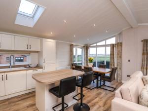 a kitchen and living room with a table and chairs at Holly Lodge in Whitby +32 photos