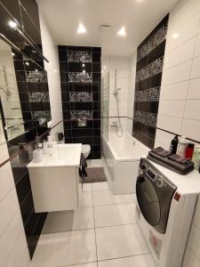 a bathroom with a toilet and a sink and a tub at Salnas rezidence self check-in in Riga
