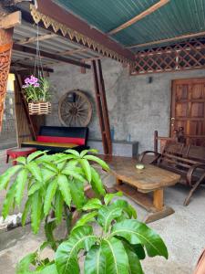 a patio with a wooden table and a wheel at Archary Lanta Apartment in Ko Lanta